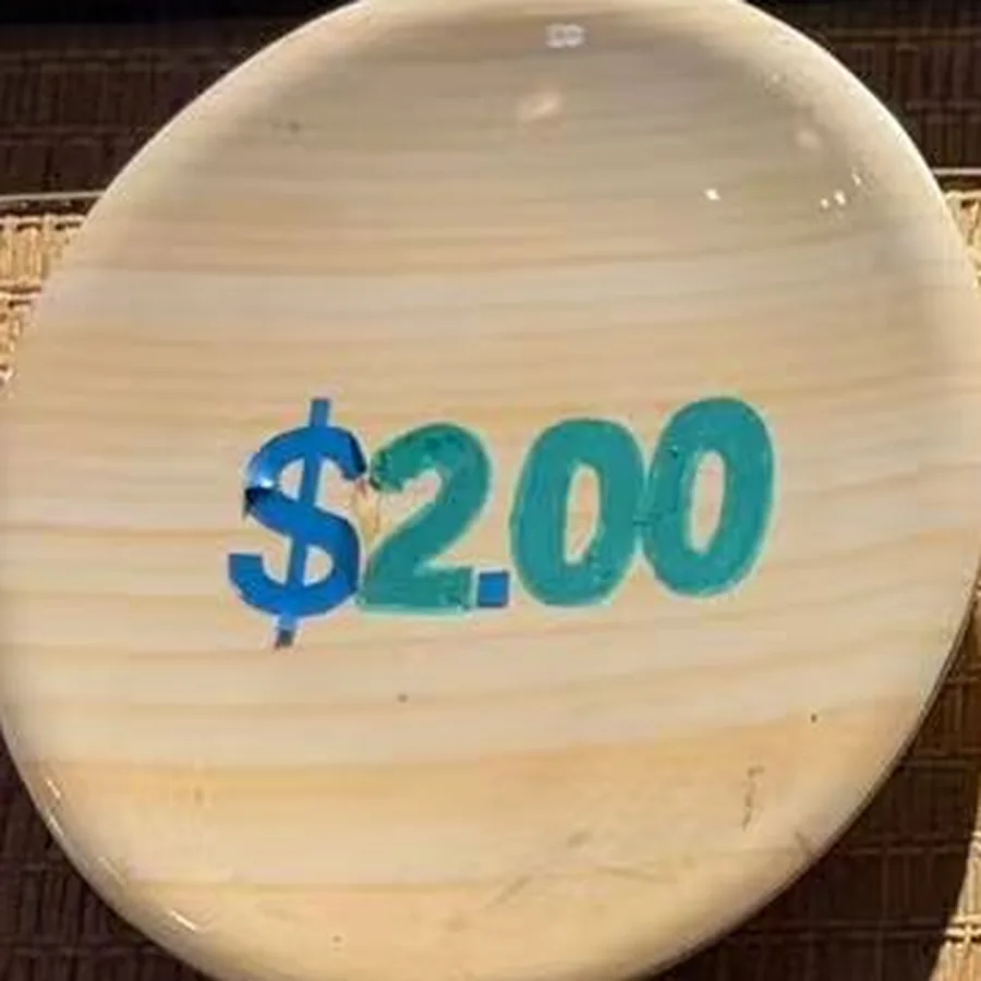 The wood plate — pale wood grain with $2.00 painted across it